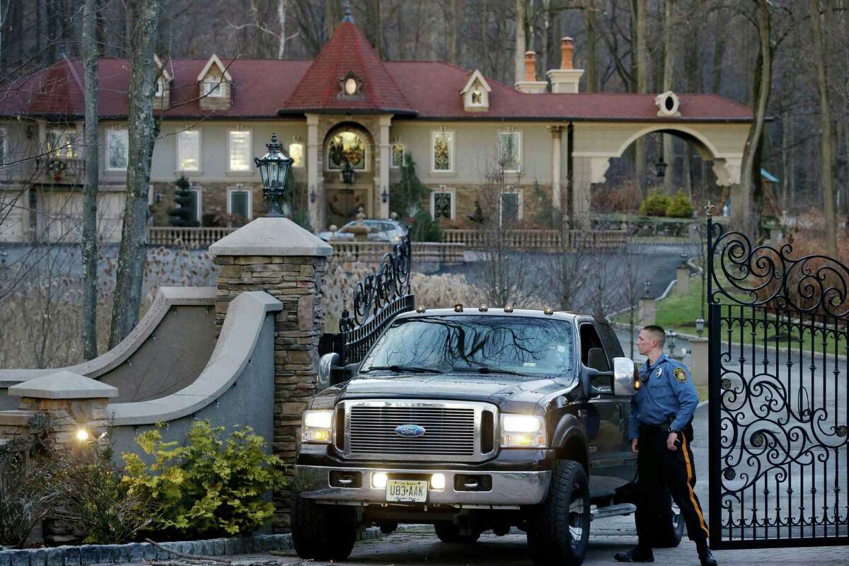 A police officer talks with the driver of a truck carrying children from the home of Teresa Giudice, a cast member of Bravo's "Real Housewives of New Jersey," and her husband Giuseppe "Joe" Giudice Monday, Jan. 5, 2015, in the Towaco section of Montville Township, N.J. Teresa Giudice is scheduled to report to a federal prison in Danbury, Connecticut, on Monday morning to begin serving a 15-month sentence for bankruptcy fraud. U.S. District Judge Esther Salas staggered her sentence with her husband's so they wouldn't be in prison at the same time and unable to care for their four daughters. She and her husband pleaded guilty last year and admitted hiding assets from bankruptcy creditors and submitting phony loan applications to get some $5 million in mortgages and construction loans.