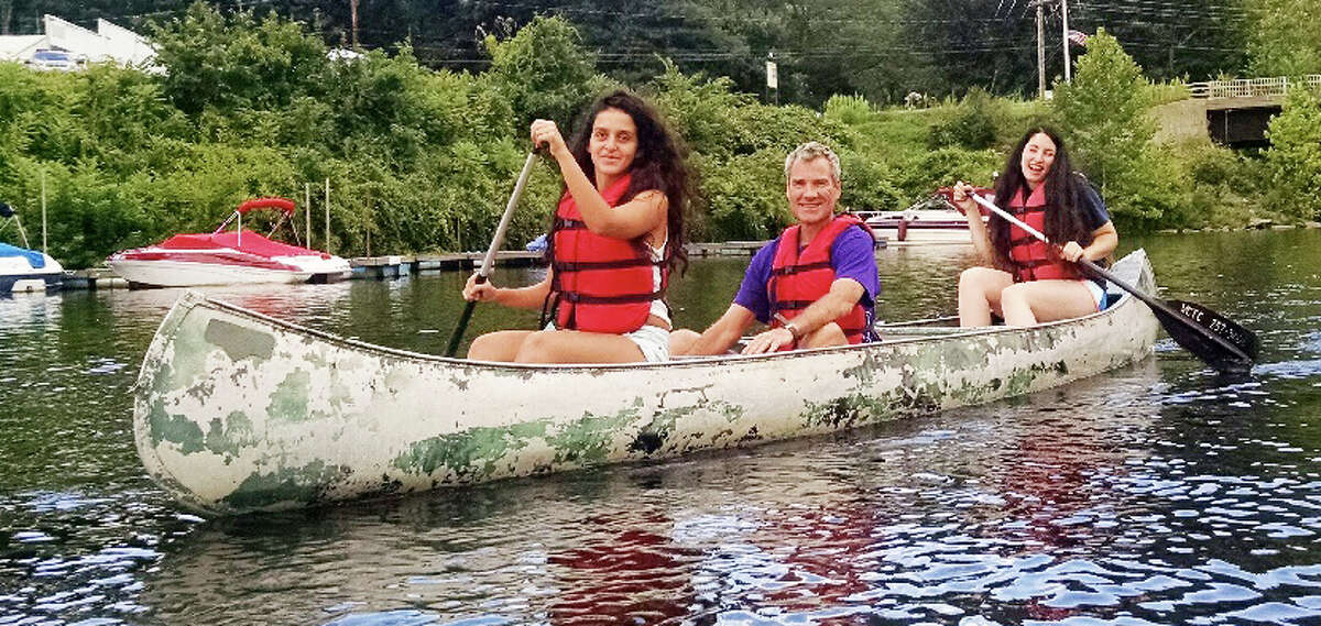 An international trio of campers at Jerulasem Peacebuilders team up for a canoe trip on the Connecticut River. From left are Palestinian Leen Baransah, American Mike Pardee and Israeli Inbar Navon.