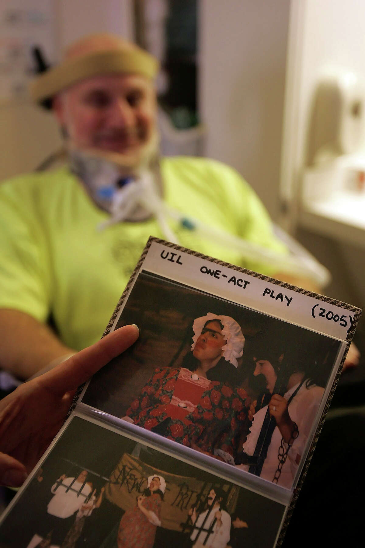 Robert Rehm's sister Janice Walker holds a photo album Wednesday Aug. 17, 2005 in Houston at The Institute of Rehabilitation and Research showing pictures from the play Rehm, background, was working one when he had his accident. (WILLIAM LUTHER/STAFF)