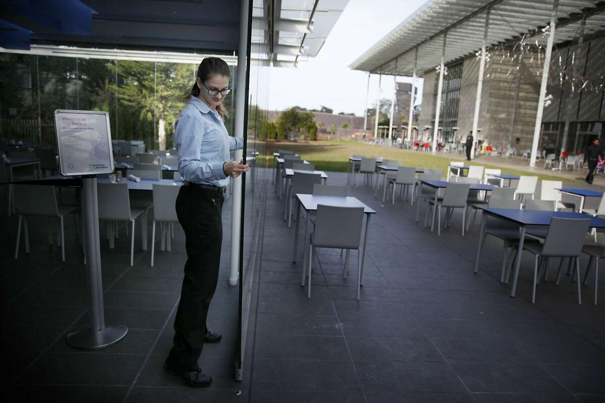 Vanessa Schagerer, supervisor The Terrance, moves a panel of the retractable glass wall as she demonstrates how the restaurant has the option of folding open its walls at the California Academy of Sciences on Monday, January 5, 2015 in San Francisco, Calif.
