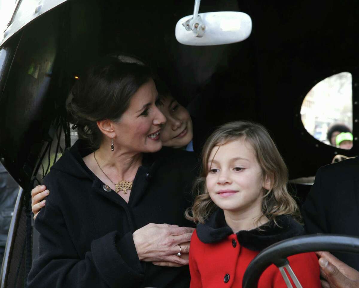 Oakland Mayor-elect Libby Schaaf gets a hug from her son Dominic, 9, with her daughter Lena, 7, in an art car at the Paramount Theater in Oakland, Calif., for her inauguration on Monday, January 5, 2015.