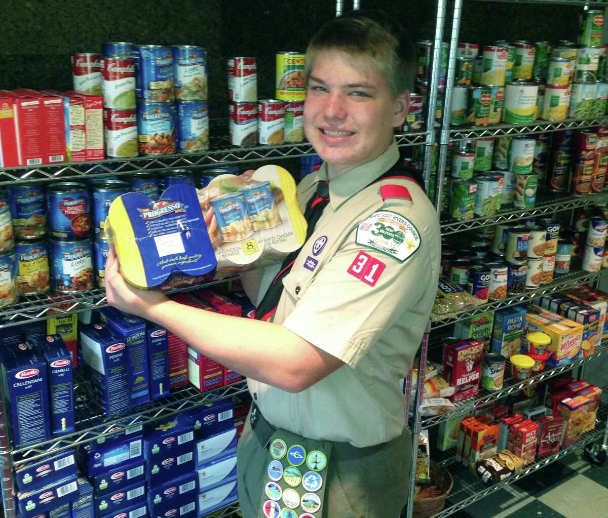 Eagle Scout Pete Kivela of New Milford poses for a keepsake photo in the relocated food pantry at Bridgewater Congregational Church. For more photos, visit www.newmilfordspectrum.com. 2014 Courtesy of the Kivela family