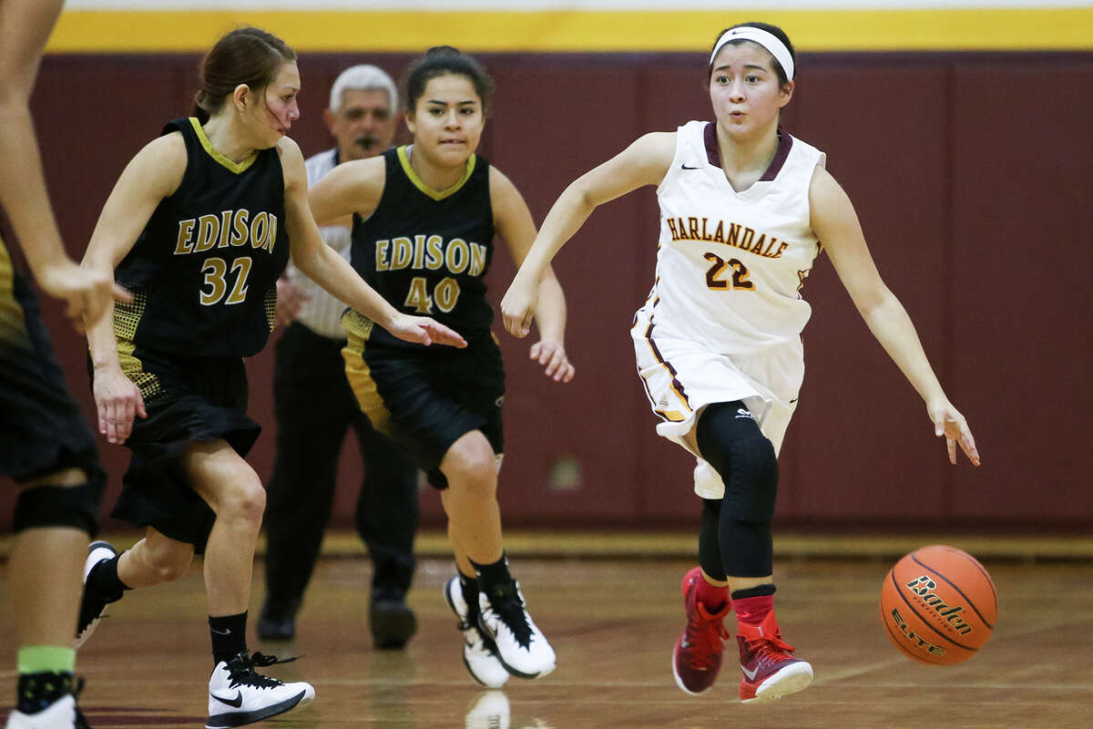 Harlandale's Justyne Perez (from right) brings the ball upcourt past Edison's Victoria Rodriguez and Jasmin Chapa during their game at Harlandale on Tuesday, Dec. 30, 2014. The Lady Indians beat Edison 50-41. MARVIN PFEIFFER/ mpfeiffer@express-news.net