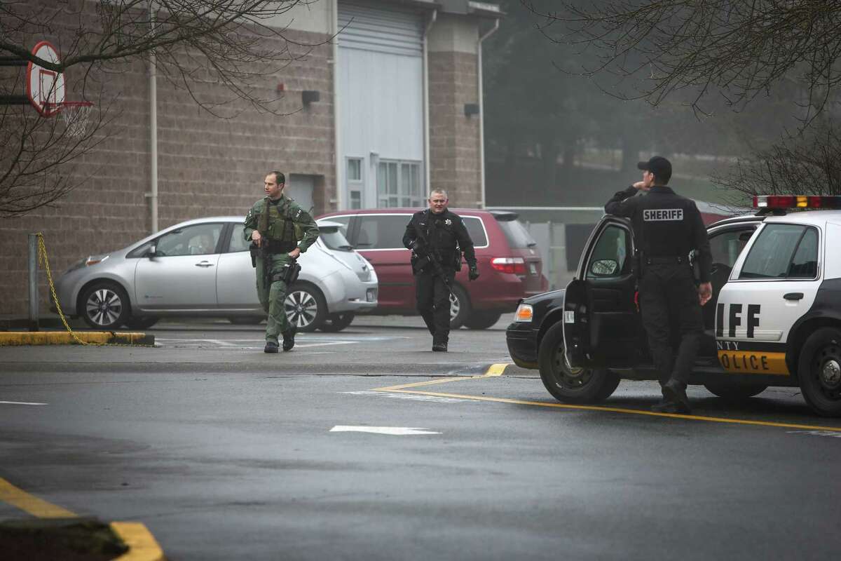 Deputies with automatic rifles search the grounds of The Evergreen School after a man with a gun was seen at nearby Meridian Park School in Shoreline on Wednesday, January 7, 2015. An employee of the school said the man threatened the school, prompting the closure of schools across the district.