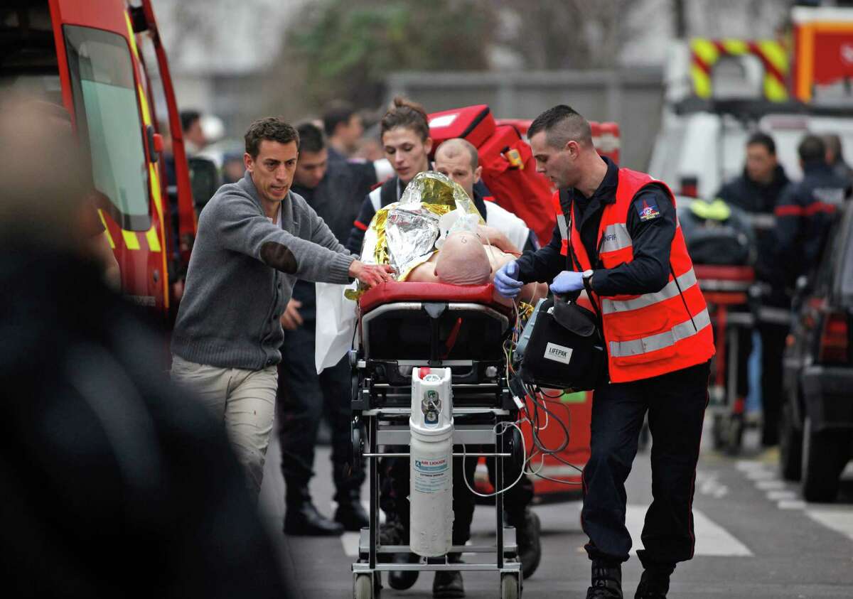 In Paris, on Jan. 7, an injured person is transported to an ambulance after a shooting at the offices of the satirical newspaper Charlie Hebdo.