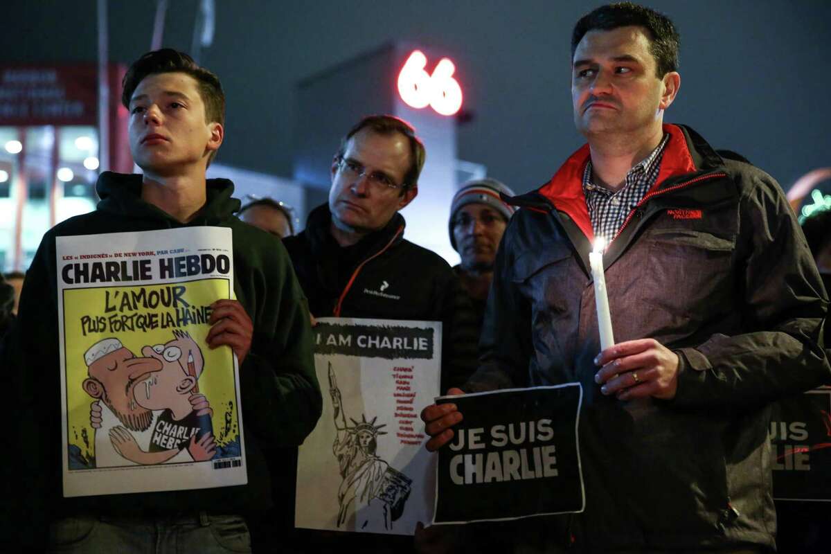 People gather for a vigil in Seattle after a shooting at the French satirical publication Charlie Hebdo left 12 people dead. Gunmen stormed into the Paris office, killing employees of the publication that were gathered for a meeting. Islamic extremists claimed responsibility for the attack. Photographed on Wednesday, January 7, 2014.