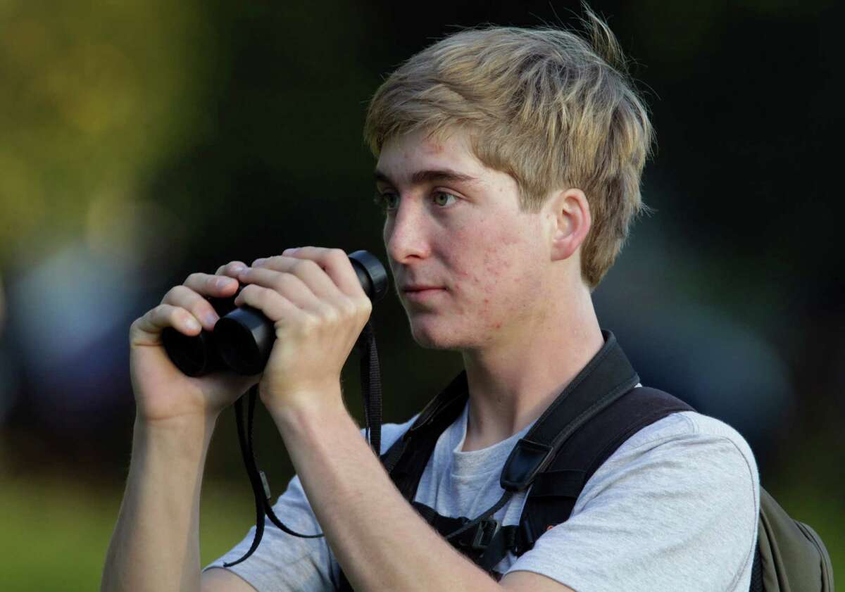 Bird enthusiast Logan Kahle, 17, looks for a rustic bunting at Golden Gate Park in San Francisco, Calif. on Tuesday, Jan 6, 2015. Birdwatchers are flocking to the park to catch a glimpse of the rare species.