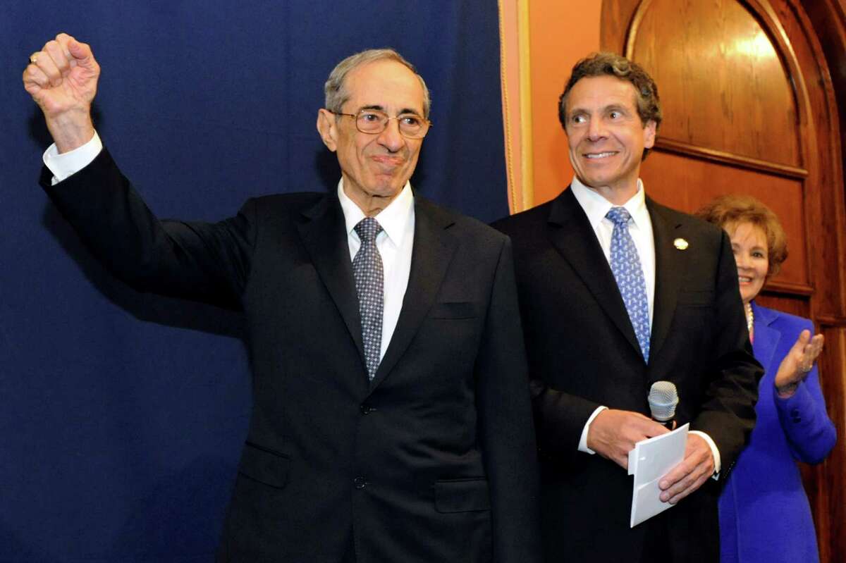 Former Gov. Mario Cuomo, left, pumps his fist as the crowd cheers before his portrait is revealed in the Hall of Governors on Saturday, June 15, 2013, at the Capitol in Albany, N.Y. Joining him are his son, Gov. Andrew Cuomo, center, and the former First Lady Matilda Cuomo. (Cindy Schultz / Times Union)