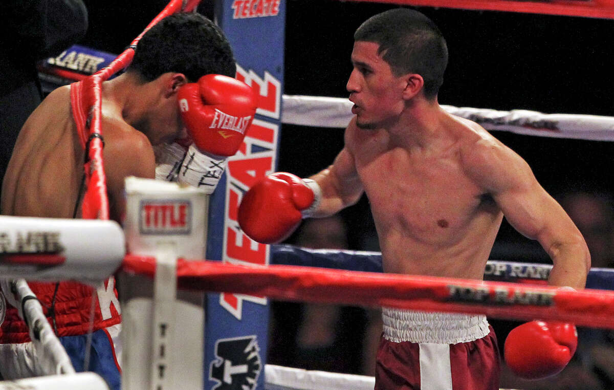 Adam Lopez punches his opponent Ramon Bayala into the ropes during their fight at the Alamodome on March 31, 2012.