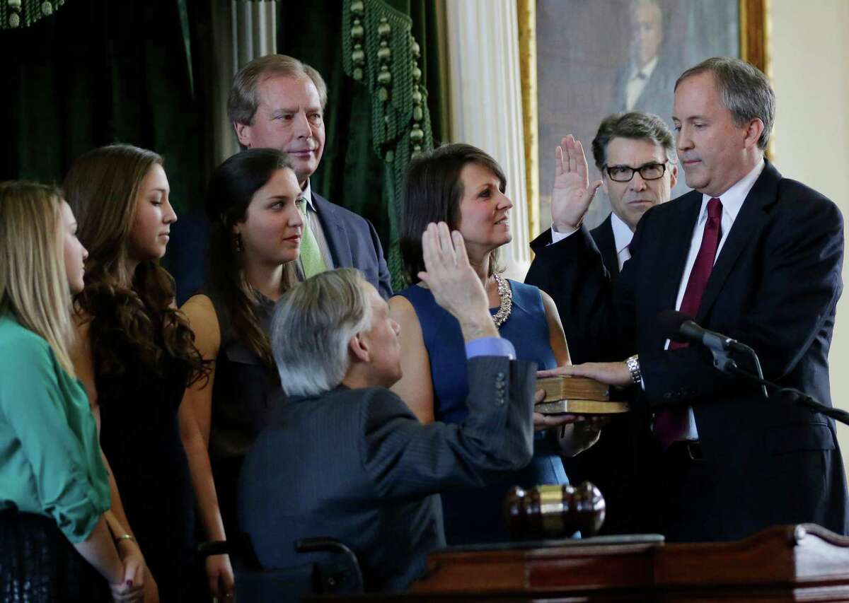 Ken Paxton, right, is sworn in as Texas attorney general by Gov.-elect Greg Abbott, center, Paxton is joined by his family and Gov. Rick Perry, second from right. A reader says Paxton’s legal issues will damage his credibility as a public official.