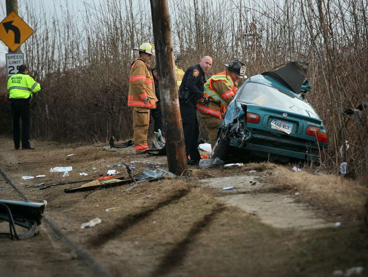 Milford police and firefighters respond to the scene of a fatal car accident on Gulf Street near Gulf Beach in Milford on Sunday afternoon, February 28, 2010.