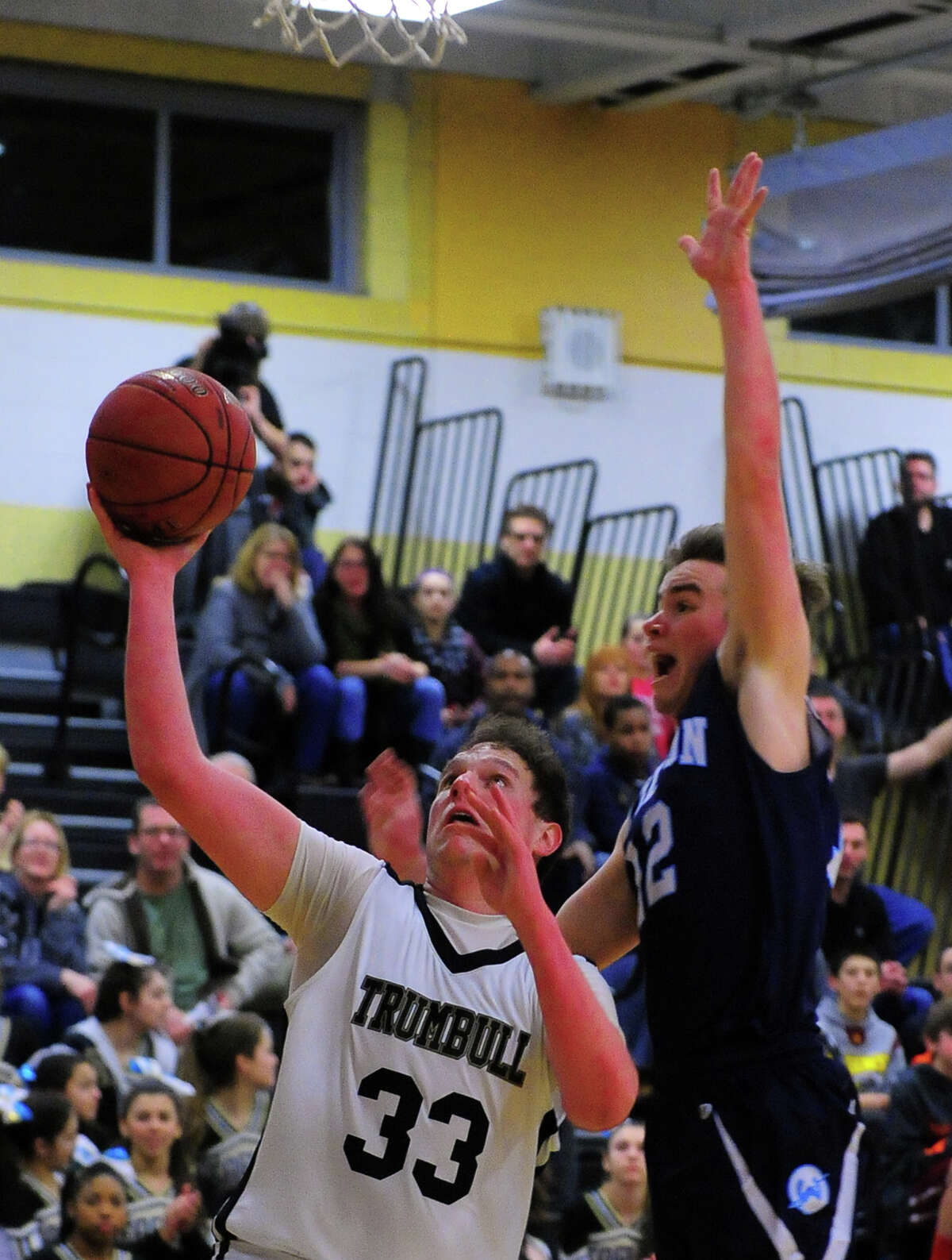 Trumbull's Ben McCullough looks for two under the hoop as Wilton's Matt Shifrin defends, during basketball action in Trumbull, Conn., on Friday Jan. 9, 2015.