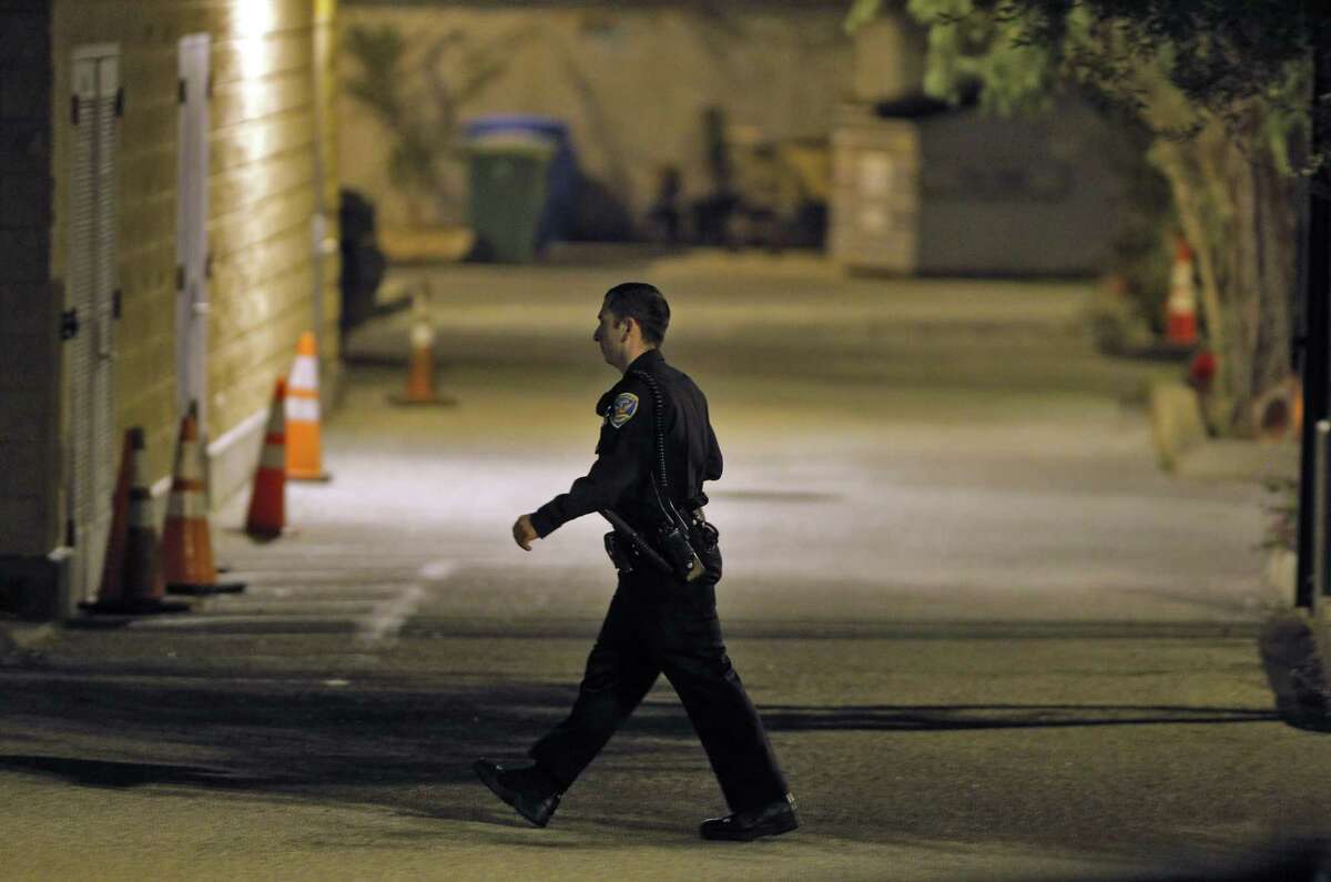 A San Francisco police officer walks through a parking lot at the Mission Station after an officer-involved shooting there.