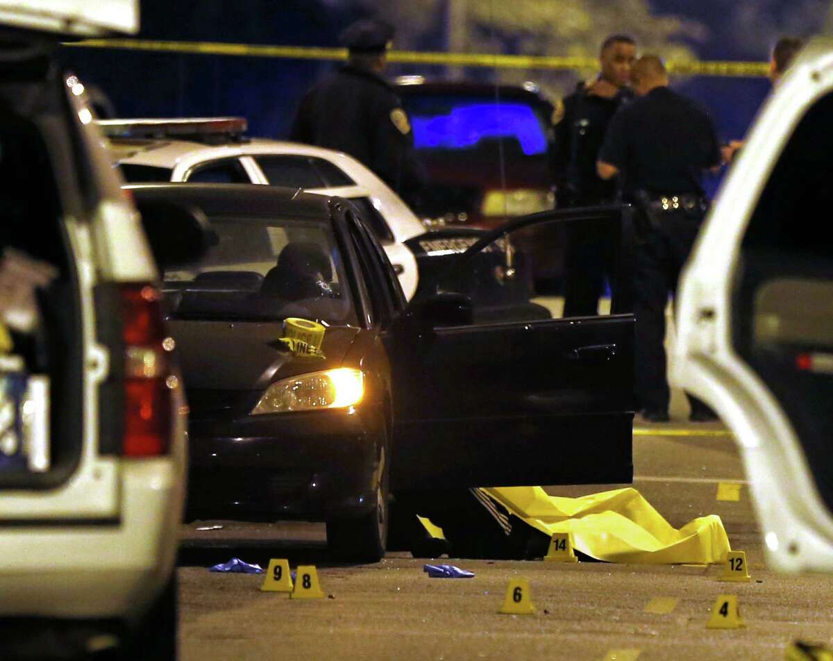 A car sits at the scene of a quadruple homicide on Laguna Street near Page Street in San Francisco on Friday.
