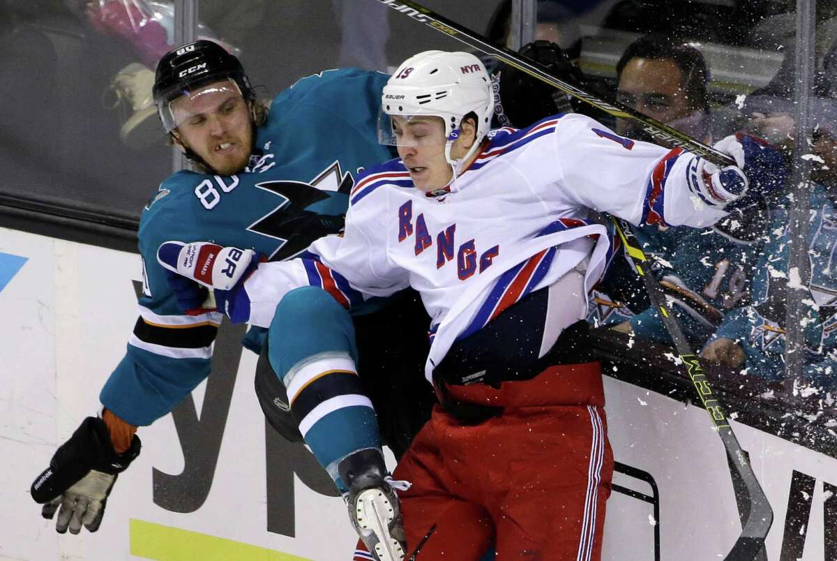 The Sharks’ Matt Tennyson and Rangers’ Jesper Fast collide along the boards during the second period of New York’s 3-1 victory. San Jose has lost three in a row at SAP Center after an eight-game home win streak.