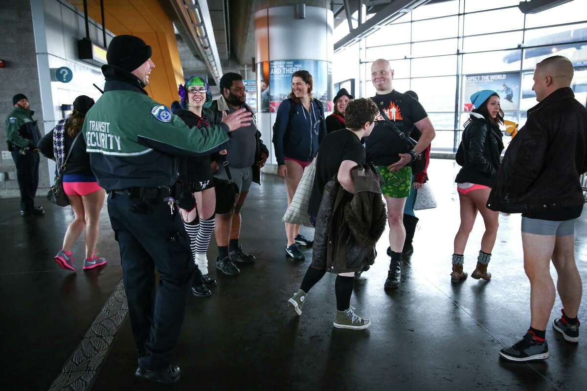 Participants are greeted by Sound Transit security during Seattle's 6th annual No Pants Light Rail Ride. During the quirky annual event, participants strip down to their underwear and ride the rail as if nothing is unusual. They also make stops along the route, often surprising people. Photographed on Sunday, January 11, 2015 in Seattle.
