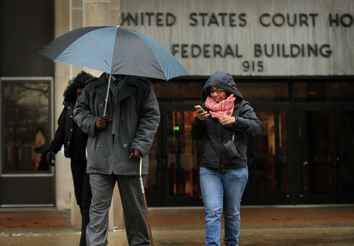 Bridgeport Police Officer Clive Higgins hides himself with an umbrella as he exits Federal Court in Bridgeport, Conn. on Monday, January 12, 2015 where he is standing trial for the 2011 beating of Orlando Lopez Soto. Higgins was videotaped with two others officers kicking Lopez Soto on the ground following a car chase. The other officers, Elson Morales and Joseph Lawlor, pleaded guilty in June.