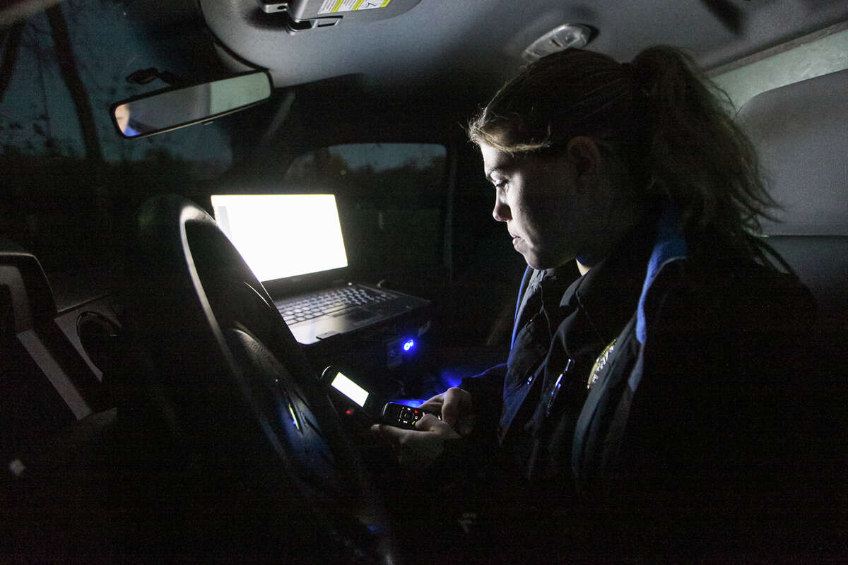 Officer Annamarie Cozzi of Animal Care Services places a phone call after getting her next assignment in the cab of her truck Dec. 23 on her night shift rounds. on Tuesday, Dec. 23.2014. MARVIN PFEIFFER/ mpfeiffer@express-news.net