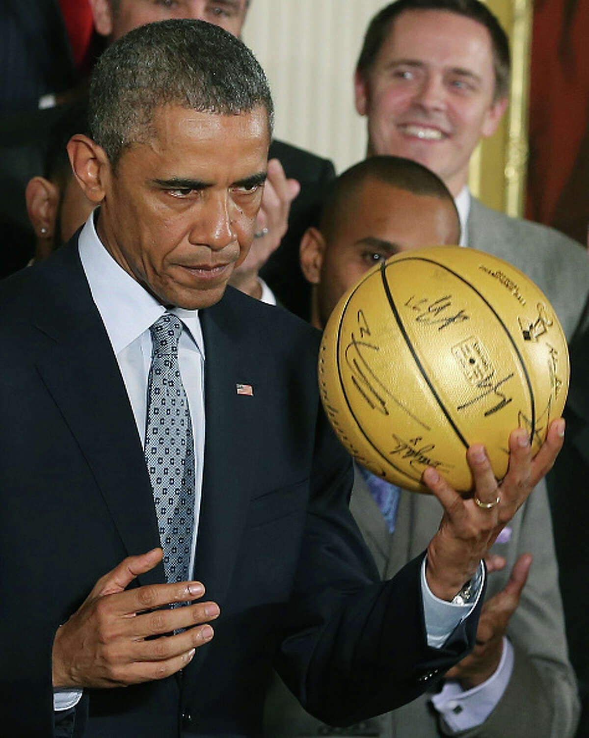 WASHINGTON, DC - JANUARY 12: U.S. President Barack Obama holds a basketball given to him by the 2014 NBA Champion San Antonio Spurs during an event in the East Room at the White House, January 12, 2015 in Washington, DC. President Obama honored the Spurs for winning their fifth NBA championship by beating the Miami Heat in game five with a 104-87 victory. (Photo by Mark Wilson/Getty Images)