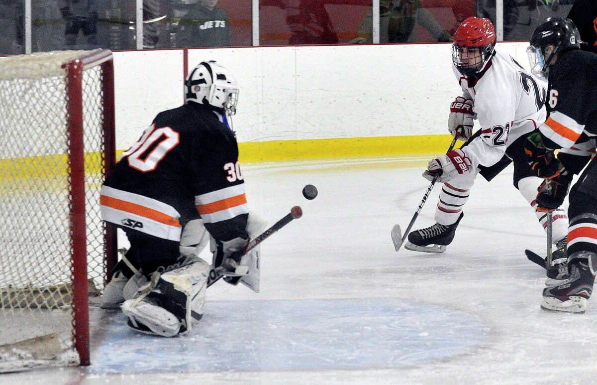 Greenwich's Matthew Lodato shoots on Stamford goalie Conor McDonough while under pressure from Stamford's Ryan Sexton, at right, during their hockey game at Dorothy Hamill Skating Rink in Greenwich, Conn., on Monday, Jan. 12, 2015. Greenwich won, 8-1.