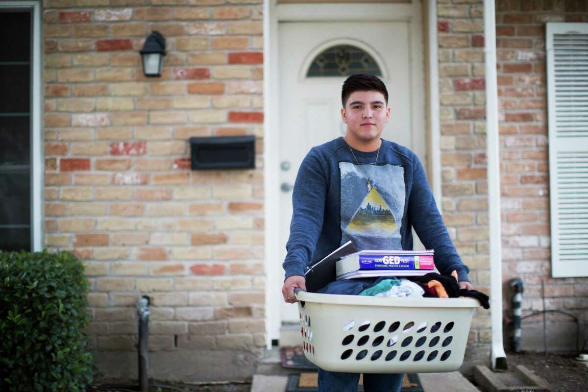 Edgar Ontiveros, 18, holds half of his worldly possessions. On top of his clothes is a GED study guide; he missed so much school court officials told him to sign himself out of high school, find a job and take the high school equivalency exam.