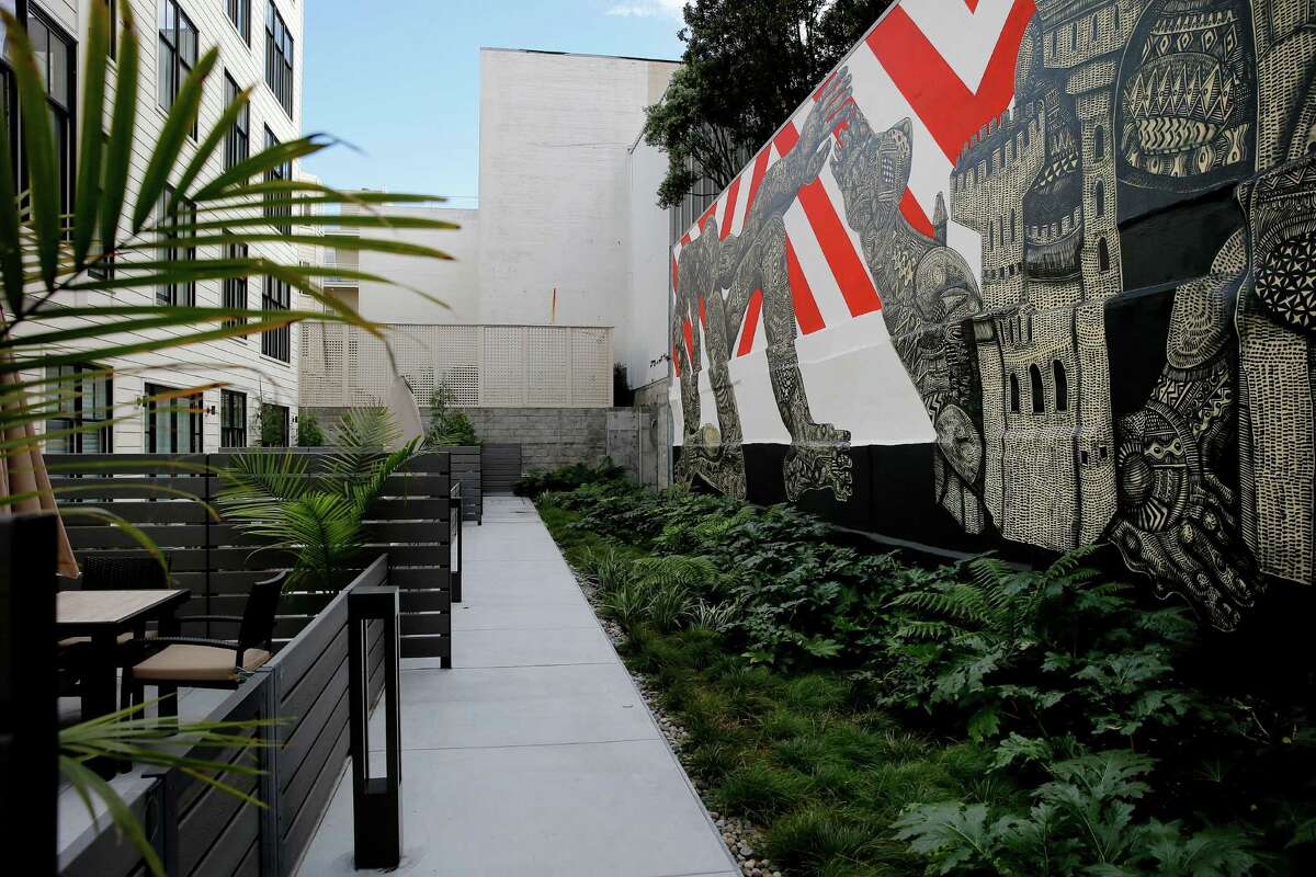 Looking down a walkway in the rear of the building at 1645 Pacific Monday January 12, 2015. The mural, seen only by residents, is by Zio Ziegler.