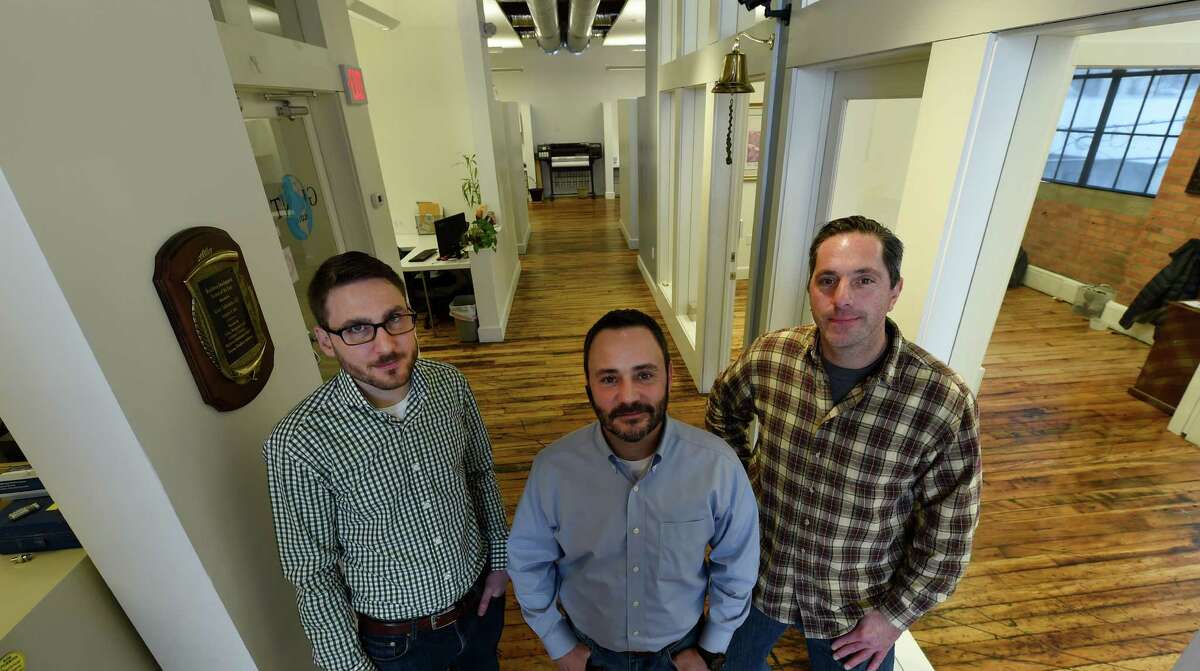 Bretton McCarthy, left, stands in the offices of Giant Solutions with David Putman, center, and Scott Stockman Wednesday afternoon, Jan. 7, 2015, in Amsterdam, N.Y. (Skip Dickstein/Times Union)