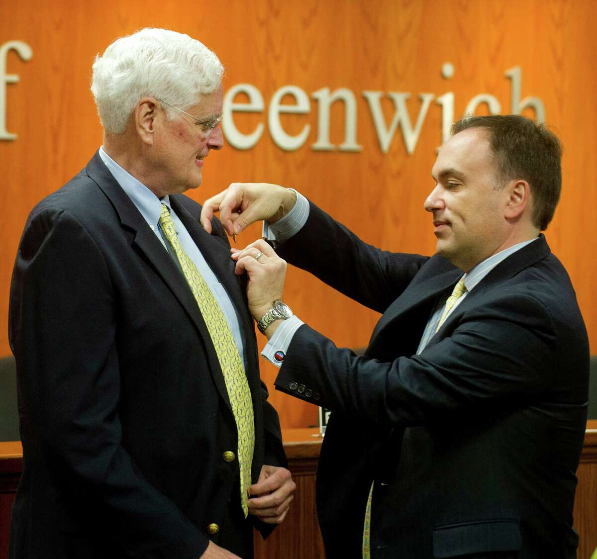 John Toner gets a town of Greenwich pin from First Selectman Peter Tesei before Toner is sworn-in as Selectman during a special meeting at Greenwich Town Hall in Greenwich, Conn., on Wednesday, January 14, 2015, to fill the position left by the death of Dave Theis.