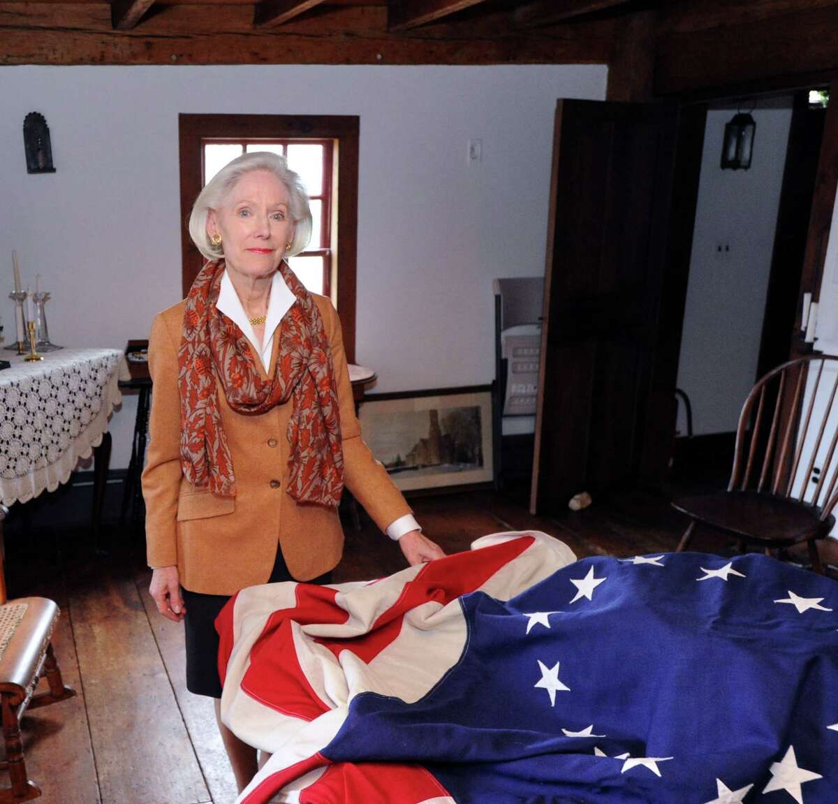 Davidde Strackbein, chair of the 375th Anniversary Committee, with a Betsy Ross replica flag of United States of America, inside historic Putnam Cottage at 243 E. Putnam Ave., Greenwich, Conn., Wednesday, Jan. 14, 2015. Greenwich is celebrating the 375th anniversary of its founding. On Sunday, Feb. 22, the Daughters of the American Revolution will provide a re-enactment at Putnam Hill Park featuring Gen. Israel Putnam's escape from invading British forces in 1779. Town officials will also rededicate Putnam Hill Park and there will be public tours of Putnam Cottage.