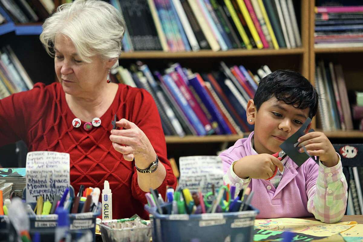 Second grade teacher Prudence Hull (left) and Lisandro Santos (right), 7 years old, work on creating a Keith Haring pop art piece in art teacher Ellen Weinstein's class at Clarendon elementary school in San Francisco, Calif., on Wednesday, January 14, 2015.