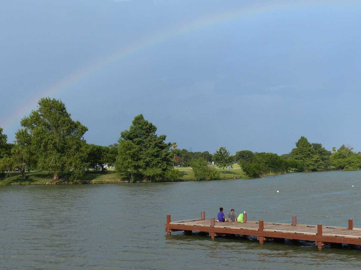 A rainbow upstairs in the sky as children fish at Woodlawn lake on Saturday, July 5, 2014, just hours before a fireworks show was to be put on. The show was a make-up for the July 4 show, which was shortened because of weather.