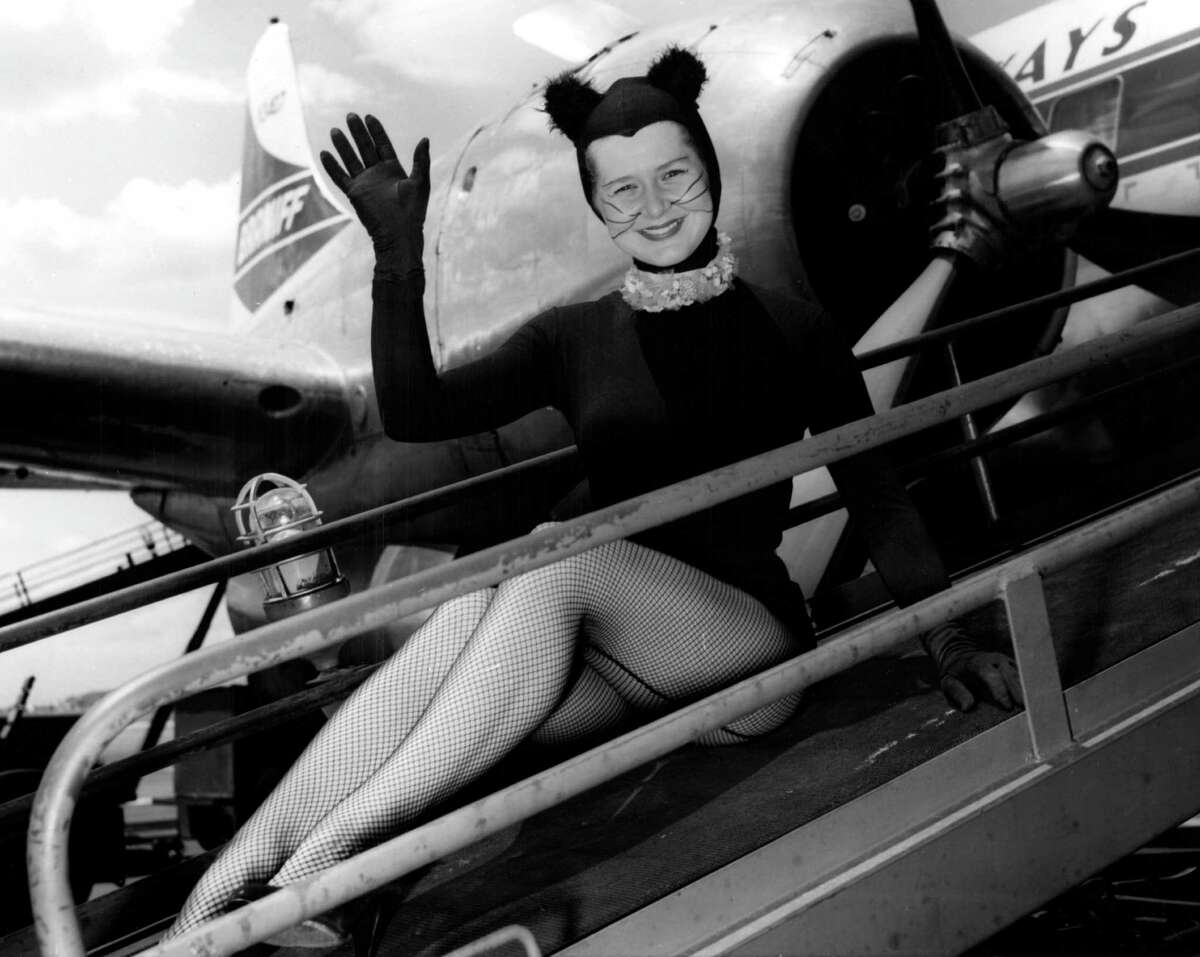 From August 1958: Kitirik, Channel 13's black cat mascot, is shown here riding the baggage chute into the plane she took off in this morning from the Houston International Airport. Airport officials had a tough time deciding whether Kitirik (Bunny Orsak) should ride in the plane with the passengers or in the baggage compartment, where most animals are shipped. But when cute Kitirik flashed her sparkling smile, they put her in the plane, and she took off waving goodbye to her fans for one week.