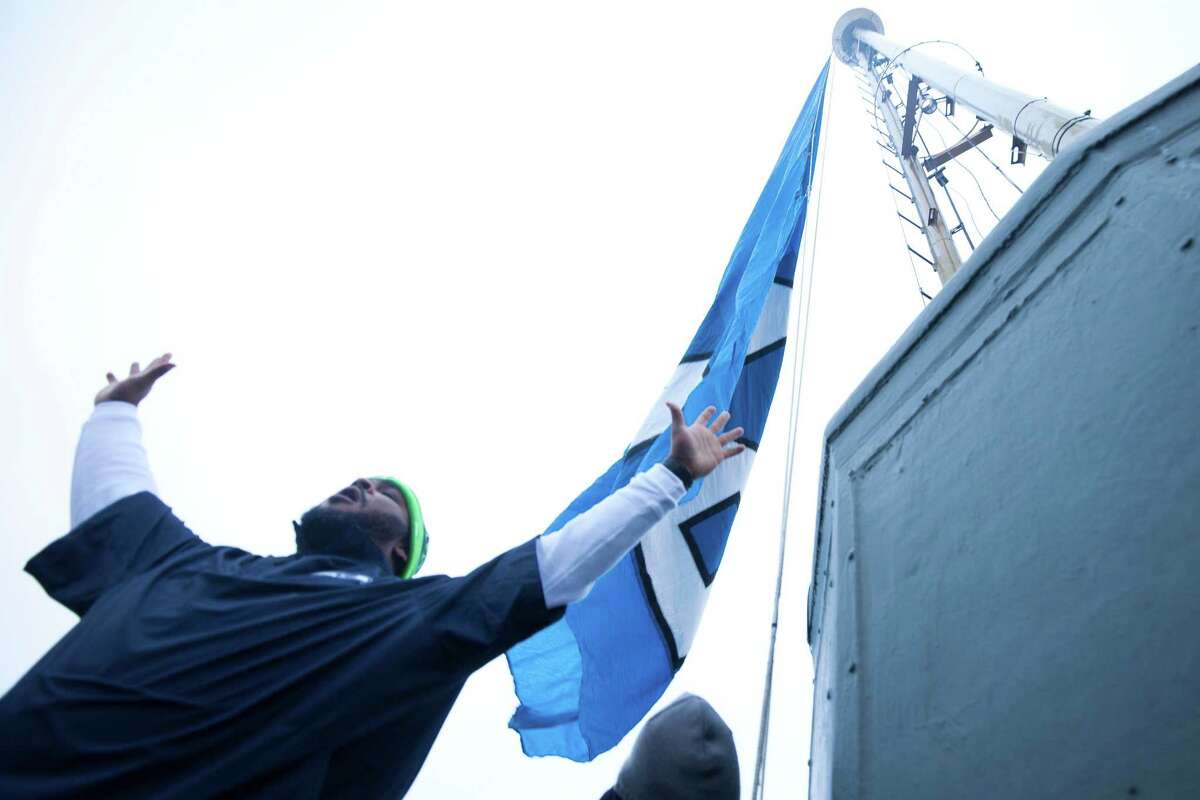 Former Seahawks player Walter Jones had the honor of raising the 12th man flag on top of the Space Needle in celebration for the Seahawks' upcoming NFC Championship game against the Green Bay Packers.