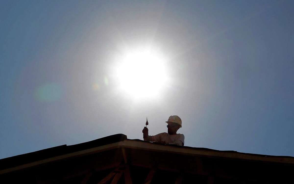 FILE - In this July 25, 2014 file photo, a roofer works under the mid-day sun in Gilbert, Ariz. Federal science officials announced Friday that for the third time in a decade, the globe sizzled to the hottest year on record. Both the National Oceanic and Atmospheric Administration and NASA calculated that in 2014 the world had its hottest year in 135 years of record-keeping. Earlier, the Japanese weather agency and an independent group out of University of California Berkeley also measured 2014 as the hottest on record. (AP Photo, File)