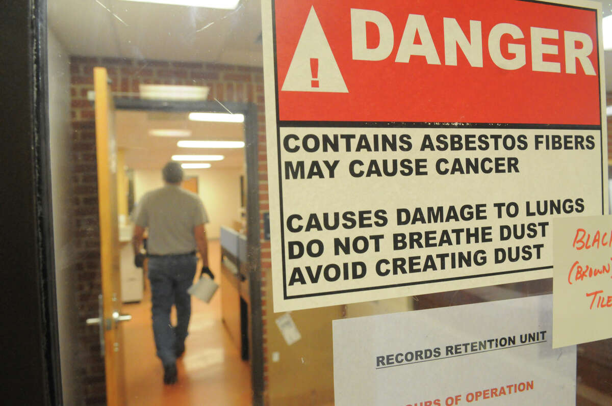Signs warning of asbestos posted throughout the Stamford Police Station in Stamford, Conn., Dec. 12, 2014.
