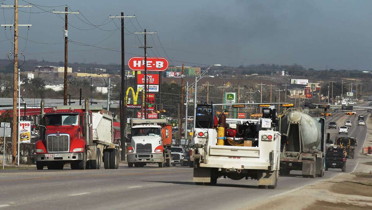 Work trucks make their way along a busy U.S. 181 in Kenedy on Friday. Recent drops in oil prices have resulted in job cuts in the industry. Despite the price slump, local officials have not seen any slowdown in the town located in the heart of Eagle Ford. (Kin Man Hui/San Antonio Express-News)
