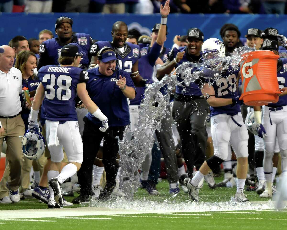 TCU coach Gary Patterson avoids getting ice water poured on him by players following a the Horned Frogs’ win over Mississippi in the Peach Bowl in Atlanta, on Dec. 31, 2014. TCU won 42-3.