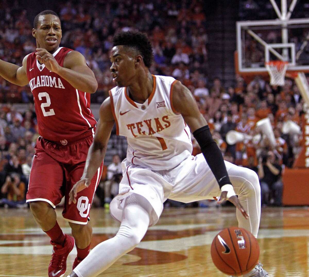 Texas guard Isaiah Taylor (1) looks to drive against Oklahoma guard Dinjiyl Walker (2) during the first half an NCAA college basketball game, Monday, Jan. 5, 2015, in Austin.
