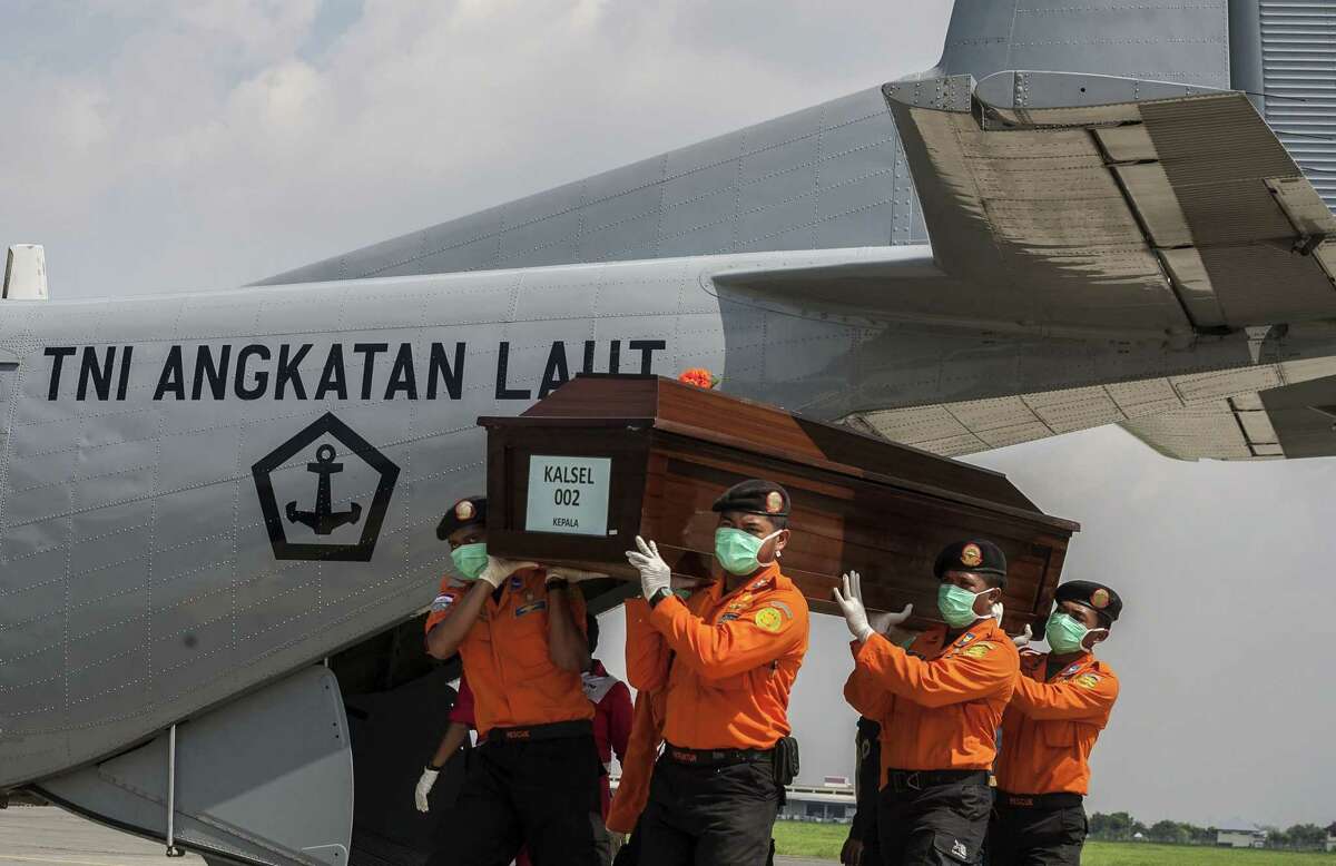 National disaster agency officers carry a coffin with the remains of a passenger of AirAsia Flight 8501 in Surabaya.