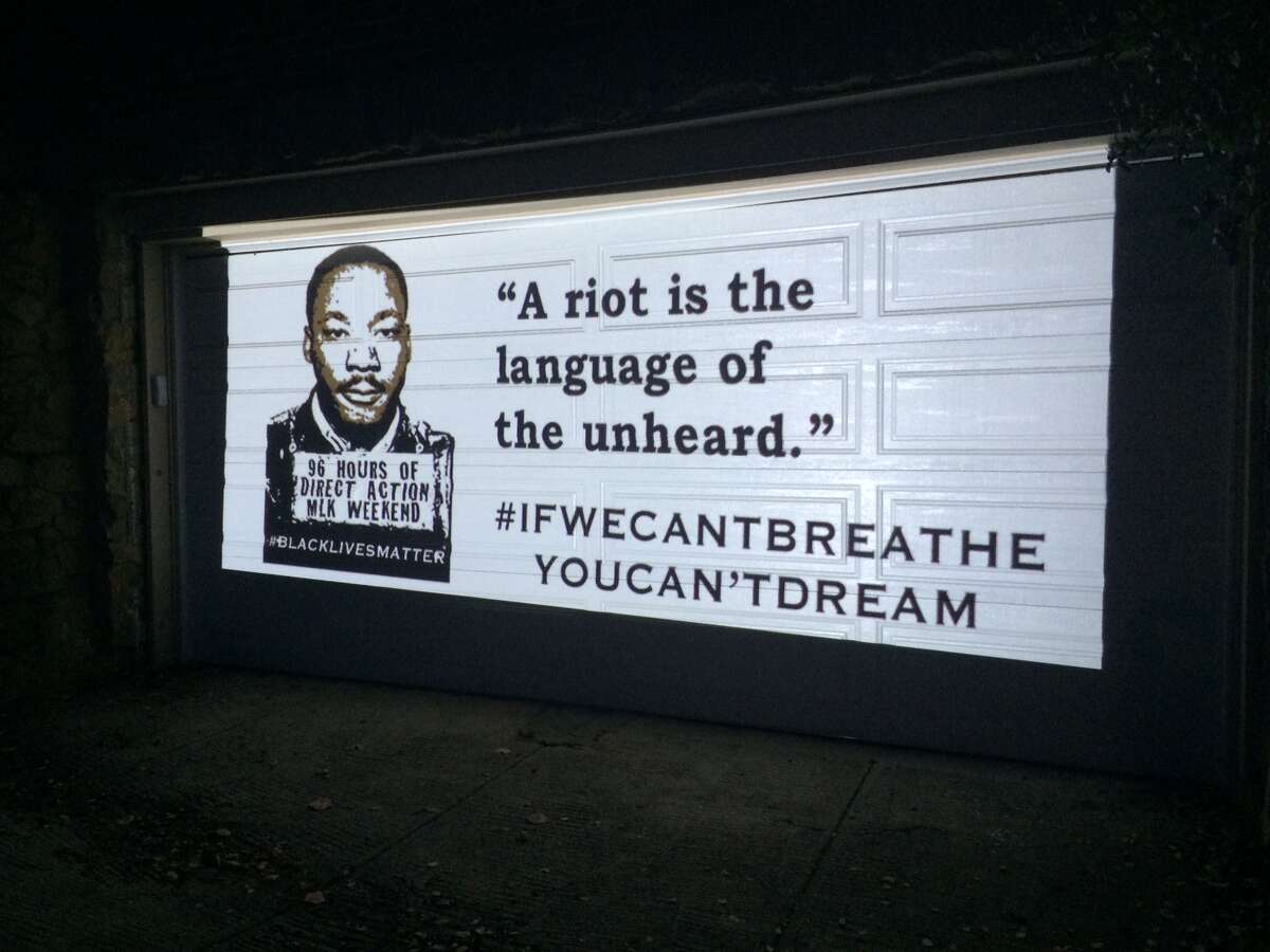 Slides of Martin Luther King's quotes were projected on Oakland Mayor Libby Schaaf's garage door early this morning. Demonstrators, voicing their frustrations with injustices against African Americans, gathered in front of Schaaf's home early Monday morning on Dr. Martin Luther King Jr. Day.