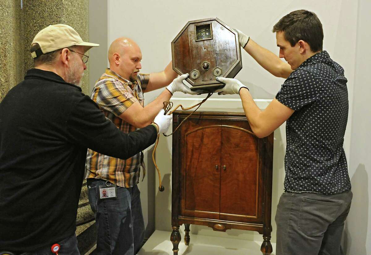 From left, New York State Museum workers Gregory Brown, Scott Heydrick and Brett Stageman install a 1928 television at the new exhibit titled "New York's Bold Ideas: Inventions that Changed the Human Condition" on the second floor of the Capitol on Tuesday, Jan. 20, 2015 in Albany, N.Y. This television set received the broadcast of Governor Al Smith accepting the Democratic Party nomination for President of the United States. (Lori Van Buren / Times Union)