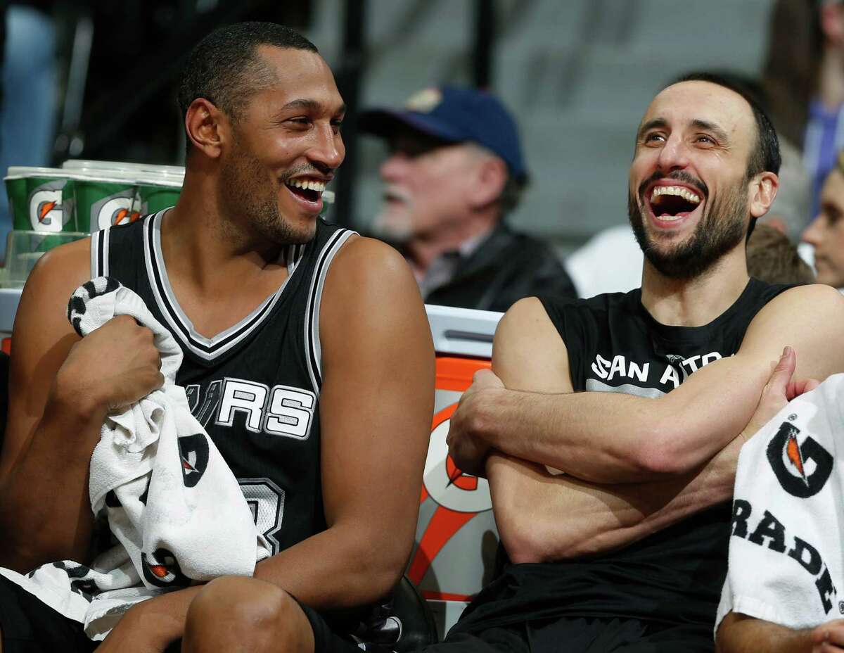 Boris Diaw jokes with guard Manu Ginobili on the bench late in the fourth quarter of the Spurs' 109-99 win in Denver.