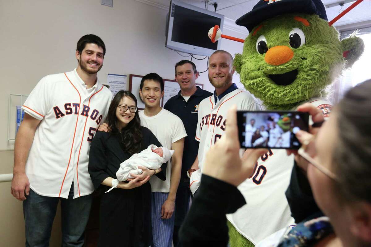 Astros Mark Appel, Chris Sampson, Kevin Chapman, and Orbit are photographed with parents Jennifer Ho and Philip Ho holding their new baby during the 2015 Houston Astros Caravan at Houston Methodist Hospital on Tuesday, Jan. 20, 2015, in Houston.