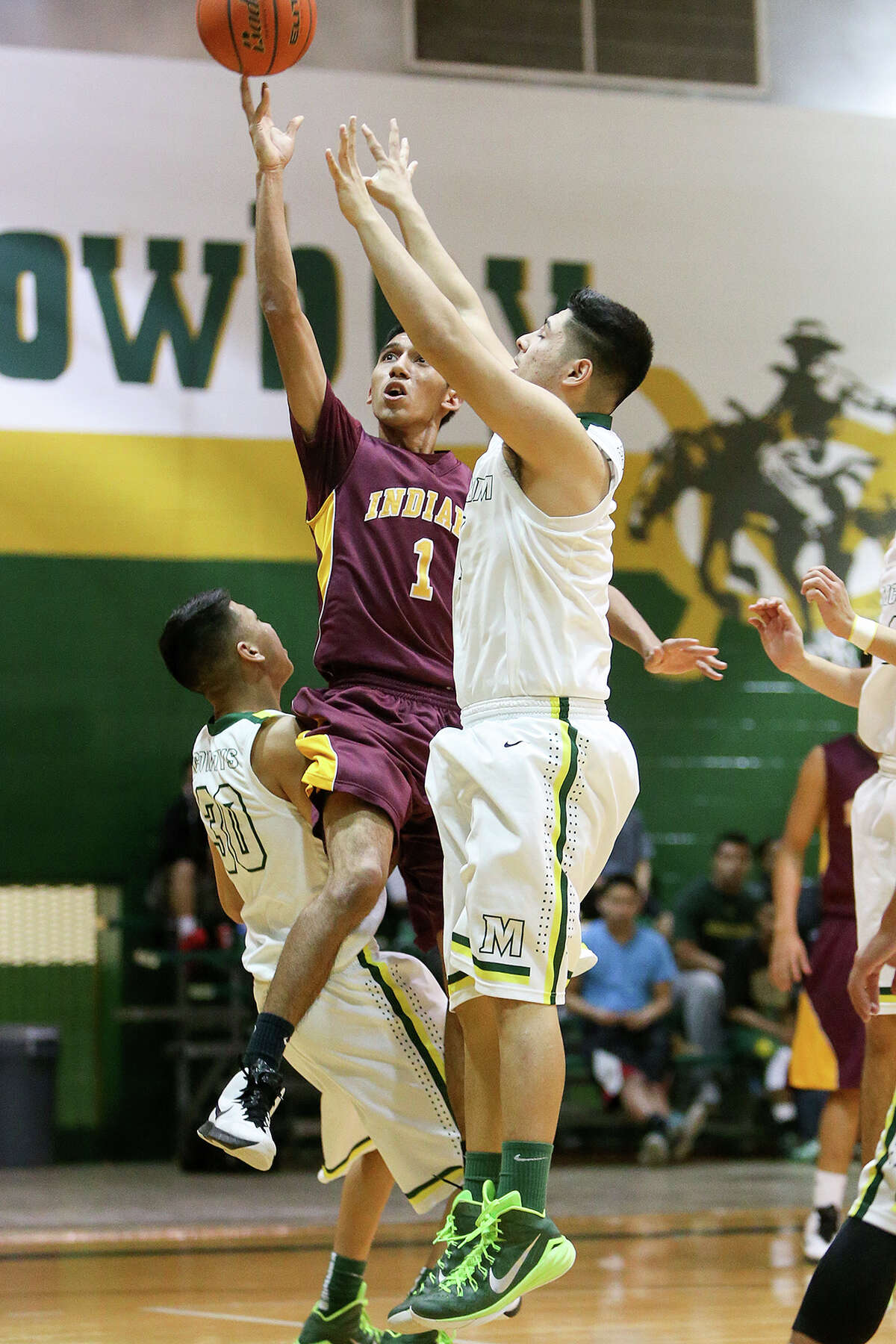 Harlandale's Jesus Maltos (center) shoots between McCollum's Angel Loera (left) and Danny Lerma during the first half of their game at McCollum on Friday, Jan. 16, 2015. McCollum beat Harlandale 52-50. MARVIN PFEIFFER/ mpfeiffer@express-news.net