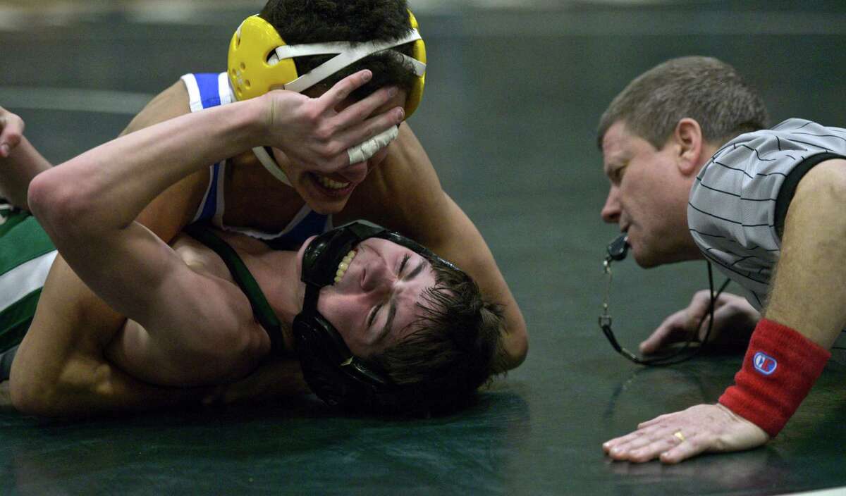 Newtown's Tom Leuci, top, tries to pin New Milford's Colin Linder whilen wrestling in the 106 pound weight class during a high school wrestling meet between Newtown and New Milford high schools, at New Milford High School, in New Milford, Conn, on Wednesday, January 21, 2015. Referee John Kwiatkowski move closer to get a better view.