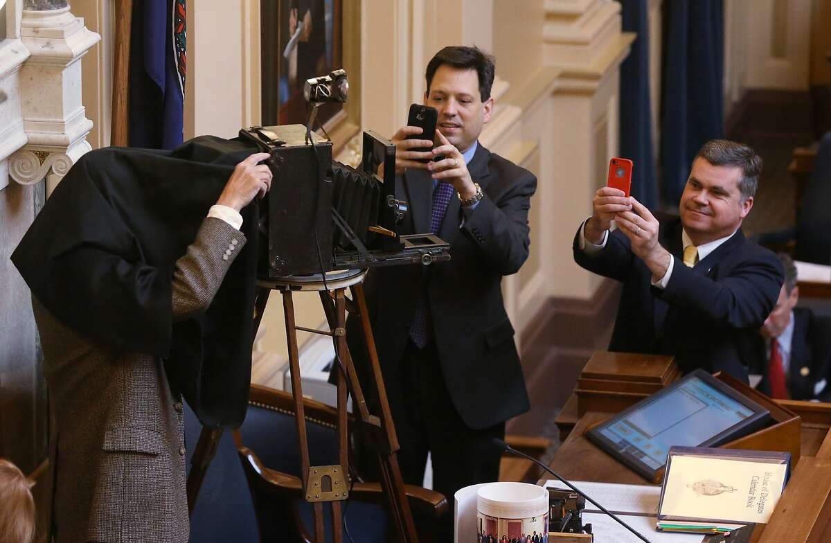 SIRI, MEET YOUR GREAT, GREAT GRANDFATHER: Delegates Scott A. Sourvell and Del. James E. Edmunds II (right) photograph Douglas B. Chadwick as he checks the focus of his 1920 Cirkut panoramic camera before taking a class picture of the Virginia House of Delegates at the State Capitol in Richmond.