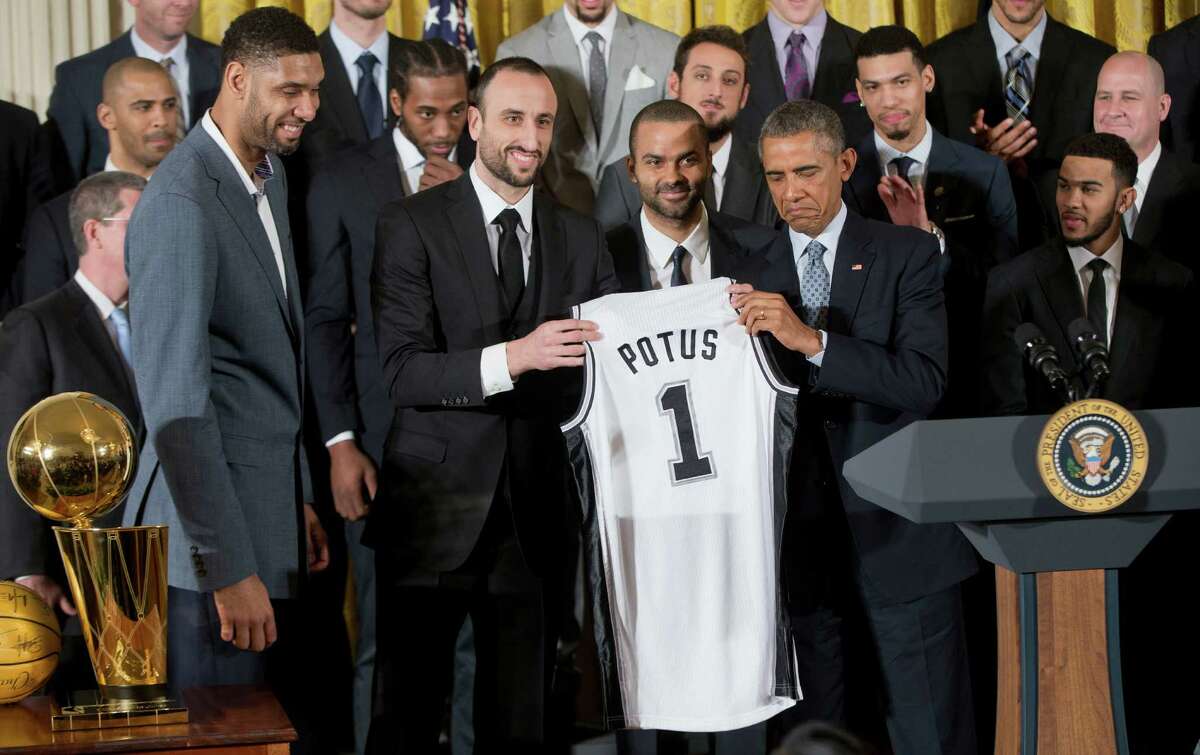 President Barack Obama, honoring the 2014 NBA champions at the White House recently, accepts a San Antonio Spurs jersey from team members. A reader explains why the Spurs are so successful.