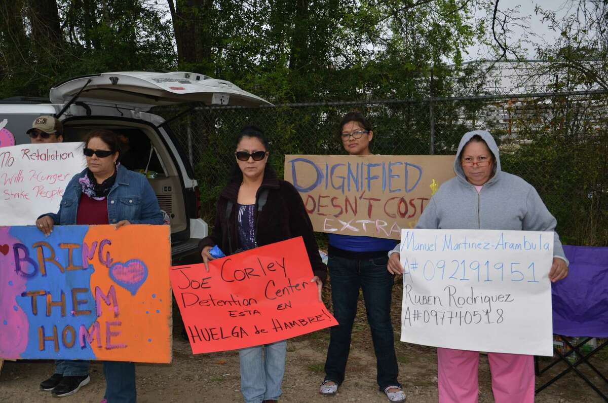 Relatives of undocumented immigrants who are detained in the Joe Corley Detention Facility, located in Conroe (TX), gather outside the facility with signs showing support for the hunger strike some of the detainees started on March 17, 2014 to demand no more deportations and better living conditions at the facility (La Voz / Houston Chronicle).