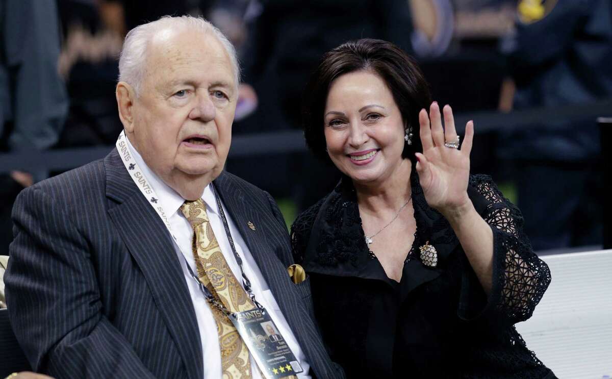 New Orleans Saints owner Tom Benson sits on the sideline with his wife, Gayle Benson, before an NFL football game against the Green Bay Packers on Oct. 26 in New Orleans.