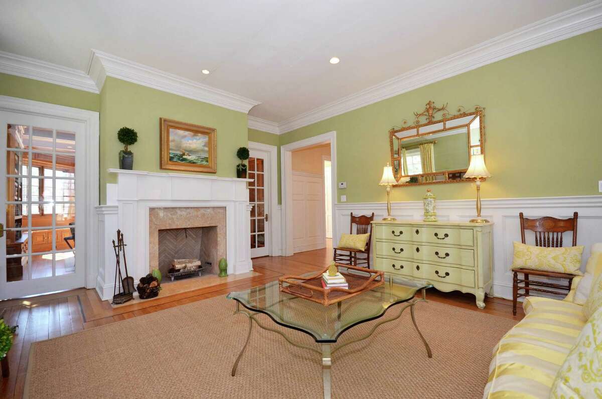 A marble fireplace with a hand-carved mantel is a prominent feature of the living room.